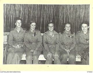 LAE, NEW GUINEA. 1944-08-09. MEMBERS OF THE AUSTRALIAN ARMY NURSING SERVICE WAITING FOR THEIR PARTNERS DURING A DANCE ORGANISED BY THE OTHER RANKS OF THE LAE BASE SUB AREA FOR STAFF MEMBERS OF THE ..