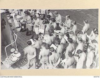 TOROKINA, BOUGAINVILLE, 1945-07-08. RATINGS ATTENDING THE NAVY CHURCH SERVICE ON THE DECK OF THE CORVETTE HMAS KIAMA, CONDUCTED BY CHAPLAIN F.O. HULME-MOIR, HEADQUARTERS 2 CORPS. PERSONNEL FROM ..