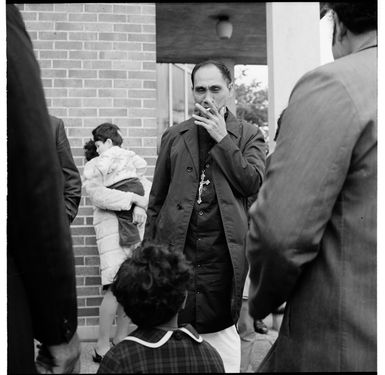 Samoan congregation outside a Catholic (?) church, Great North Road, Grey Lynn; and a family passing Mid City Motors, Great North Road, Grey Lynn, Auckland