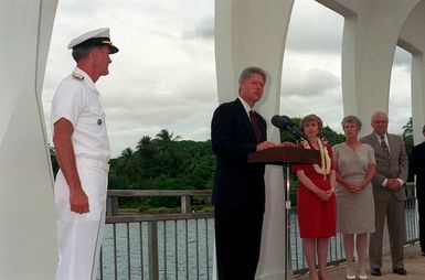 President William Jefferson Clinton speaks during a ceremony aboard the ARIZONA (BB-39) Memorial as Hillary Rodham Clinton, Secretary of Defense Les Aspin and Mrs. Aspin stand by. Clinton is in Hawaii to tour area military installations