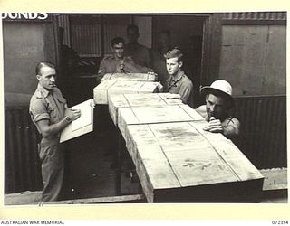 PORT MORESBY, NEW GUINEA. 1944-04-18. NX115753 WARRANT OFFICER I WOODWARD, AUSTRALIAN ARMY SERVICE CORPS, (1), AT NO. 2 COLD STORE, ELA BEACH, SUPERVISING THE LOADING OF BONELESS BEEF FOR ..