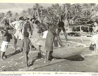 1943-01-11. ALLIED AIRMEN IN NEW GUINEA. THREE AUSSIE AIRMEN WATCH NATIVES MAKING A CANOE. THE NATIVES PRIZE THESE HIGHLY, BUT AFTER THEY HAD BROUGHT IN THE BODIES OF FOUR AUSTRALIANS KILLED IN A ..