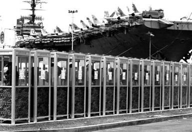 Sailors use some of the telephone booths on the pier beside the aircraft carrier USS CONSTELLATION (CV 64)