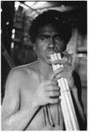 Young man plays sukukwaakwaa bundled bamboo flute