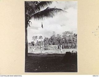 KAHILI, SOUTH BOUGAINVILLE. 1945-09-09. THE GUARD, AND LIAISON OFFICERS OF THE BUIN LIAISON GROUP, 2 CORPS, SALUTING DURING THE RAISING OF THE AUSTRALIAN FLAG AT BUIN