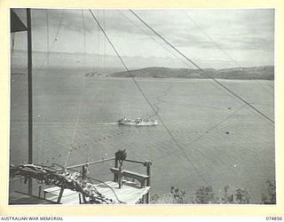 PORT MORESBY, PAPUA. 1944-07-28. THE SS "BALIKPAPAN" ENTRING THE HARBOUR THROUGH THE ANTI-SUBMARINE BOOM GATES