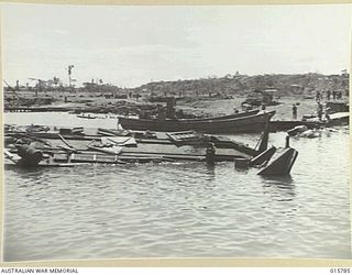 1943-09-22. NEW GUINEA. AUSTRALIAN TROOPS CAPTURE LAE. WRECKED JAPANESE BARGES AT LAE