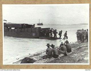 SIALUM, NEW GUINEA. 1944-01-05. PERSONNEL OF "B" ECHELON, 26TH AUSTRALIAN INFANTRY BRIGADE DISEMBARKING FROM AN LCM (LANDING CRAFT, MECHANISED)