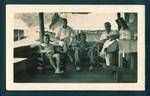 Group of men sitting on verandah, from left two unidentified men, Harry Jones and Eric Gaude, at Harry Jones house, Baiune, New Guinea, c1929 to 1932
