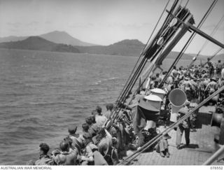 AT SEA. 1944-10-07. TROOPS OF THE 36TH INFANTRY BATTALION LINE THE RAIL OF THE DUTCH TROOPSHIP "SWEARTENHONDT" AS THE VESSEL PREPARES TO ENTER KIMBE BAY TO CALL AT TALASEA WHILE EN ROUTE FOR NEW ..