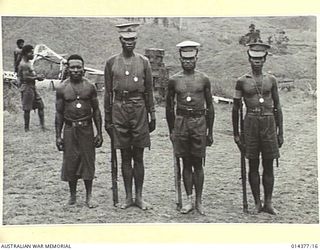 1943-03-03. THESE FOUR NATIVES RECEIVED THE FIRST LOYAL SERVICE MEDALS AWARDED IN THE TERRITORY OF NEW GUINEA. THEY WERE DECORATED FOR HAVING PROVED THEMSELVES FEARLESS, WILLING, CONSCIENTIOUS AND ..
