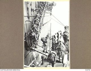 PORT MORESBY, PAPUA. 1942-09. TROOPS OF THE 25TH AUSTRALIAN INFANTRY BRIGADE DISEMBARKING FROM A TROOPSHIP TO A NAVAL CORVETTE FOR FERRYING TO THE WHARF