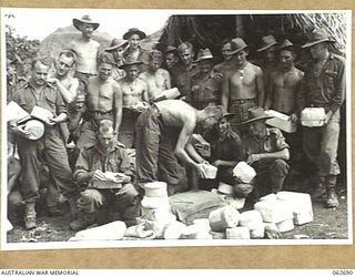 RAMU VALLEY, NEW GUINEA. 1943-12-22. PERSONNEL OF THE 2/31ST AUSTRALIAN INFANTRY BATTALION GATHER AROUND WHILE THE CHRISTMAS MAIL IS BEING SORTED