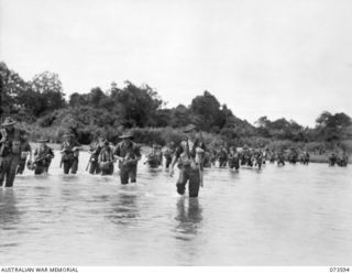 Forward troops of the 35th Infantry Battalion, crossing the river during their advance up the coast towards Wewak. Identified personnel are: N260218 Private (Pte) M Williams (1); NX90275 Pte J E ..