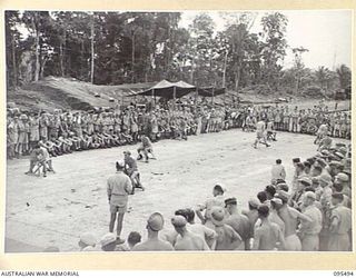 JACQUINOT BAY, NEW BRITAIN, 1945-08-23. GENERAL VIEW OF THE SPECTATORS WATCHING THE PROGRESS OF THE VICTORY CUP RACE MEETING HELD ON THE AIRSTRIP USING WOODEN HORSES CONTROLLED BY THE THROW OF A ..
