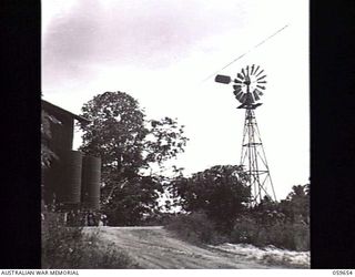 BOMANA, NEW GUINEA. 1943-11-08. CORNER OF THE BOMANA PUMPING STATION WHICH SUPPLIES PORT MORESBY WITH 1,000,000 GALLONS OF FILTERED WATER EVERY TWENTY FOUR HOURS. NOTE THE OLD WINDMILL ON THE RIGHT