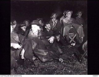 KONEDOBU (KANEDABU), NEW GUINEA. 1943-10-27. AUDIENCE AT THE SHOW STAGED BY THE 7TH AUSTRALIAN DIVISION CONCERT PARTY WELL PROTECTED FROM THE HEAVY TROPICAL RAIN. TROOPS SHELTERED UNDER ..