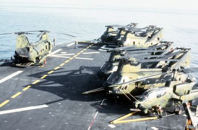 CH-46 Sea Knight helicopters and an AH-1J Sea Cobra helicopter parked on the forward flight deck of the amphibious assault ship USS GUAM (LPH-9) during flight operations off the coast of Beirut, Lebanon