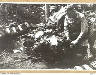 SCARLET BEACH AREA, NEW GUINEA. 1943-12-21. SX23185 STAFF SERGEANT F. W. MOLL (1) OF THE 1ST AUSTRALIAN TANK BATTALION GROUP WORKSHOP, AUSTRALIAN ELECTRICAL AND MECHANICAL ENGINEERS, WORKING ON THE ..