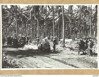 KANOMI BEACH, NEW GUINEA. 1944-01-04. GENERAL VIEW OF TACTICAL HEADQUARTERS 9TH DIVISION IN A COCONUT PLANTATION AT THE REAR OF THE BEACH