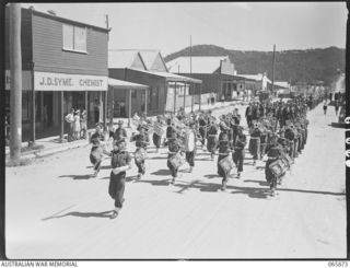 HERBERTON, QLD. 1944-04-25. THE BAND OF THE 2/2ND INFANTRY BATTALION LEADING A MARCH OF RETURNED SERVICEMEN OF THE FIRST WORLD WAR, SECOND WORLD WAR, AND TROOPS OF THE 6TH DIVISION AT J. D. SYME, ..