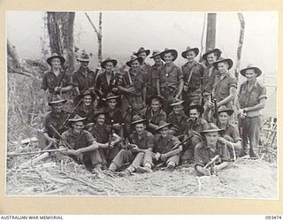 WEWAK AREA, NEW GUINEA. 1945-06-28. LIEUTENANT J.M. TRETHOWAN, PLATOON COMMANDER (1), WITH SOME OF THE MEMBERS OF HIS PLATOON. THIS PLATOON CARRIED OUT THE MAIN ACTION ON THE FEATURE DURING THE ..