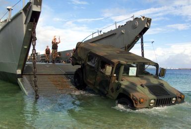 Beach MASTER 3 Brandon Schieber, Beach MASTER Unit 1, backs-in an M998 High-Mobility Multipurpose Wheeled Vehicle (HMMWV) onto Landing Craft, Utility (LCU) 1634 in Inner Apra Harbor, Guam in support of Exercise TANDEM THRUST 2003