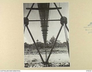 LAE, NEW GUINEA. 1944-10-18. THE SUSPENSION BRIDGE BUILT ACROSS THE BUSU RIVER BY MEMBERS OF THE 20TH FIELD COMPANY TO CARRY A SIX INCH PIPELINE FROM A NEW RESERVOIR TO SUPPLY WATER TO THE 2/7TH ..