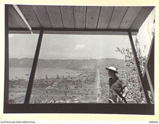 NAMANULA, RABAUL, NEW BRITAIN, 1945-10-15. THE VIEW OVER SIMPSON HARBOUR FROM THE GENERAL OFFICER COMMANDING'S MESS, HEADQUARTERS 11 DIVISION. THE COMMANDER'S HOUSE AND MESS ARE SITUATED ON THE OLD ..