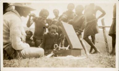 Kanakas watching and listening to the gramaphone, Bulolo, Papua New Guinea, ca. 1933 / Mr. Sturkey