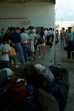 Evacuees from Naval Station, Subic Bay and Naval Air Station, Cubi Point stand in line for processing en route to the United States. Civilian and military personnel and their dependents are being evacuated from the Philippines in the aftermath of Mount Pinatubo's eruption as part of Operation FIERY VIGIL.