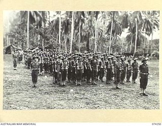 SIAR, NEW GUINEA. 1944-06-23. PERSONNEL OF D COMPANY, 57/60TH INFANTRY BATTALION STANDING TO ATTENTION DURING THE UNIT EARLY MORNING PARADE