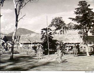 Rabaul, New Guinea, 1945-10. A long thatch-roofed hut stands on the shores of a bay at a former Japanese prisoner-of-war (POW) camp for captured Indian soldiers of the 1st Hyderabad Regiment. A ..