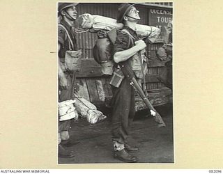 CAIRNS, QLD. 1944-10-30. PRIVATE J.F. KEATING, 2/4TH INFANTRY BATTALION (1), AWAITS EMBARKATION DURING THE MOVEMENT OF UNITS OF 6TH DIVISION TO NEW GUINEA