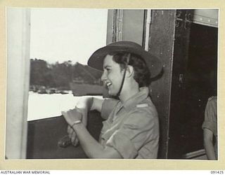 LAE, NEW GUINEA. 1945-05-07. PRIVATE L. LOBB, TAKING HER FIRST GLIMPSE OF NEW GUINEA FROM THE MV DUNTROON, BEFORE DISEMBARKING BY LANDING BARGE AT MILFORD HAVEN, EN ROUTE TO THE AWAS BARRACKS AT ..