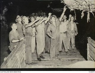 KIRIWINA, TROBRIAND ISLANDS, PAPUA. 1943-11-27. AIRMEN WORKING THROUGH THE NIGHT TO UNLOAD CARGO FOLLOWING THE MOVE OF NOS. 22 AND 30 SQUADRONS RAAF FROM GOODENOUGH TO KIRIWINA ON BOARD SS HANYANG. ..