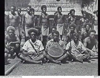 GUADALCANAL, BRITISH SOLOMON ISLANDS PROTECTORATE. 1944-01-25. GROUP PORTRAIT OF LOCAL NATIVES HOLDING A PLAQUE TO BE PRESENTED TO THE US NAVY TO COMMEMORATE THE LIBERATION OF THE SOLOMONS. ..