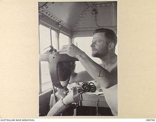 MADANG, NEW GUINEA. 1944-11-06. SUB- LIEUTENANT A KEOGH ABOARD HMAS STAWELL AT WORK ON THE BRIDGE