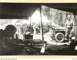 KILIGIA, NEW GUINEA, 1944-03-14. THE BIG STORE TENT, WHICH IS THE BAKERY OF THE 8TH FIELD BAKERY PLATOON, VIEWED FROM INSIDE THE UNIT'S ORDERLY ROOM. VX55524 LIEUTENANT M.A. BLAND, (1), THE PLATOON ..