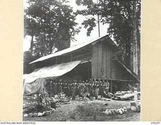 LAE, NEW GUINEA. 1944-09-27. NATIVE LABOURERS AND PERSONNEL OF THE 43RD FIELD ORDNANCE DEPOT OUTSIDE ONE OF THE UNIT WORKSHOPS