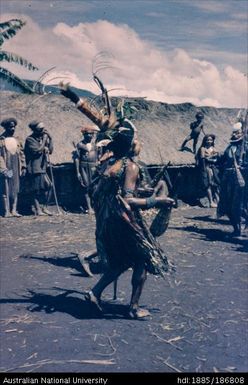 Man dancing in front of building, Tend timb