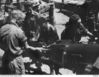 BOUGAINVILLE ISLAND. 1945-01-25. A GUN CREW OF "E" TROOP, NO.6 BATTERY, 2ND FIELD REGIMENT DEMONSTRATING TO NGN18 CORPORAL KARI, "A" COMPANY, 1ST NEW GUINEA INFANTRY BATTALION (3) THE LOADING ..