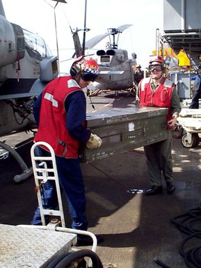 Aviation Ordnancemen move weapons from one of the ships elevators to a waiting AH-1 Sea Cobra attack helicopter. USS GUAM, an amphibious assault ship is in the Persian Gulf as part of an increased military presence to enforce UN sanctions against Iraq