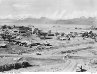 LAE, NEW GUINEA, 1944-03-27. ONE OF A SERIES OF PHOTOGRAPHS VIEWING THE WHARVES, SHIPPING, NEW ROADS, BUILDINGS AND THE AIRSTRIP WITH SALAMAUA POINT IN THE BACKGROUND. (JOINS WITH PHOTOGRAPHS ..