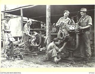 LAE, NEW GUINEA. 1944-03-24. PERSONNEL WORKING ON ENGINES IN THE ENGINE REPAIR SHOP AT THE 2/125TH BRIGADE WORKSHOP ATTACHED TO THE 7TH DEIVISION. IDENTIFIED PERSONNEL ARE: QX13987 WARRANT OFFICER ..