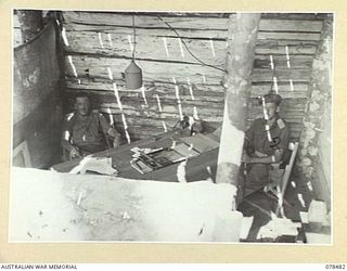 BOUGAINVILLE ISLAND. 1945-01-17. WX6152 BRIGADIER R.F. MONAGHAN, DSO, COMMANDING, 29TH INFANTRY BRIGADE (1), WITH QX42393 LIEUTENANT F.E. BROWN IN HIS OFFICE AT THE ADVANCED BRIGADE HEADQUARTERS