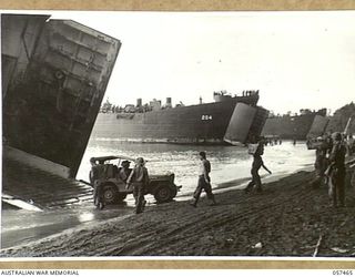 FINSCHHAFEN, NEW GUINEA. 1943-09-22. TROOPS OF THE FINSCHHAFEN FORCE UNLOADING STORES FROM LSTS (LANDING SHIP, TANK) AT THE BEACH HEAD