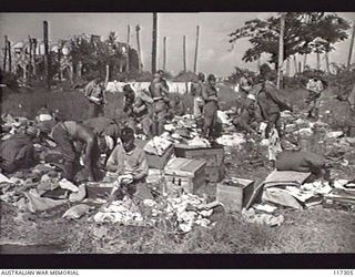 NAURU ISLAND. 1945-09-16. JAPANESE POWS REPACKING THEIR KIT AFTER AN INSPECTION PRIOR TO BEING EVACUATED TO BOUGAINVILLE SOON AFTER TROOPS OF THE 31/51ST INFANTRY BATTALION TOOK OVER THE ISLAND