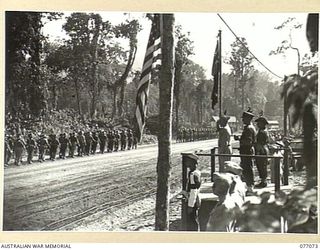 BOUGAINVILLE, 1944-11-21. MAJOR-GENERAL O. GRISWOLD, COMMANDING GENERAL XIV CORPS UNITED STATES ARMY (1) TAKING THE SALUTE FROM MEMBERS OF THE 7TH AUSTRALIAN INFANTRY BRIGADE. WITH HIM ON THE DAIS ..