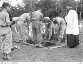 LAE AREA, NEW GUINEA. 1945-07-23. CHAPLAIN R.F. DILLON, CONDUCTING THE GRAVESIDE SERVICE FOR PRIVATE B.J. SMITH AT LAE WAR CEMETERY, HEADQUARTERS FIRST ARMY. PRIVATE B.J. SMITH WAS ACCIDENTALLY ..